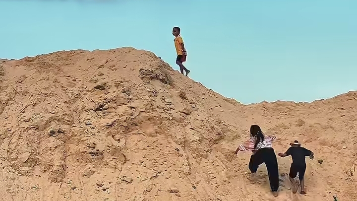 Anak-anak melintasi tumpukan tanah bekas tambang emas Kayuboko di Parigi Moutong, Sulawesi Tengah, usai penghentian aktivitas tambang oleh Bupati Erwin Burase.