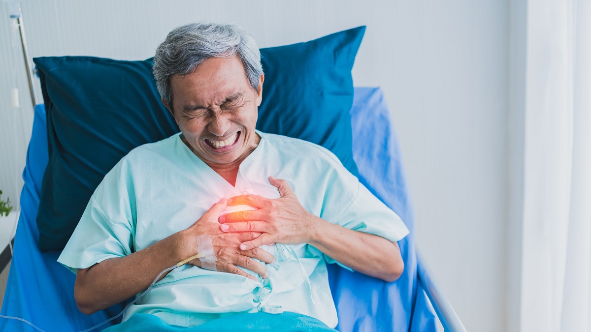 Pasien lansia memegangi dada karena gejala serangan jantung.
