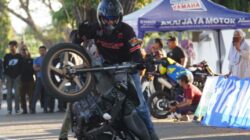 Stunt rider Kota Palu melakukan aksi ekstrem di atas motor dalam kompetisi freestyle.