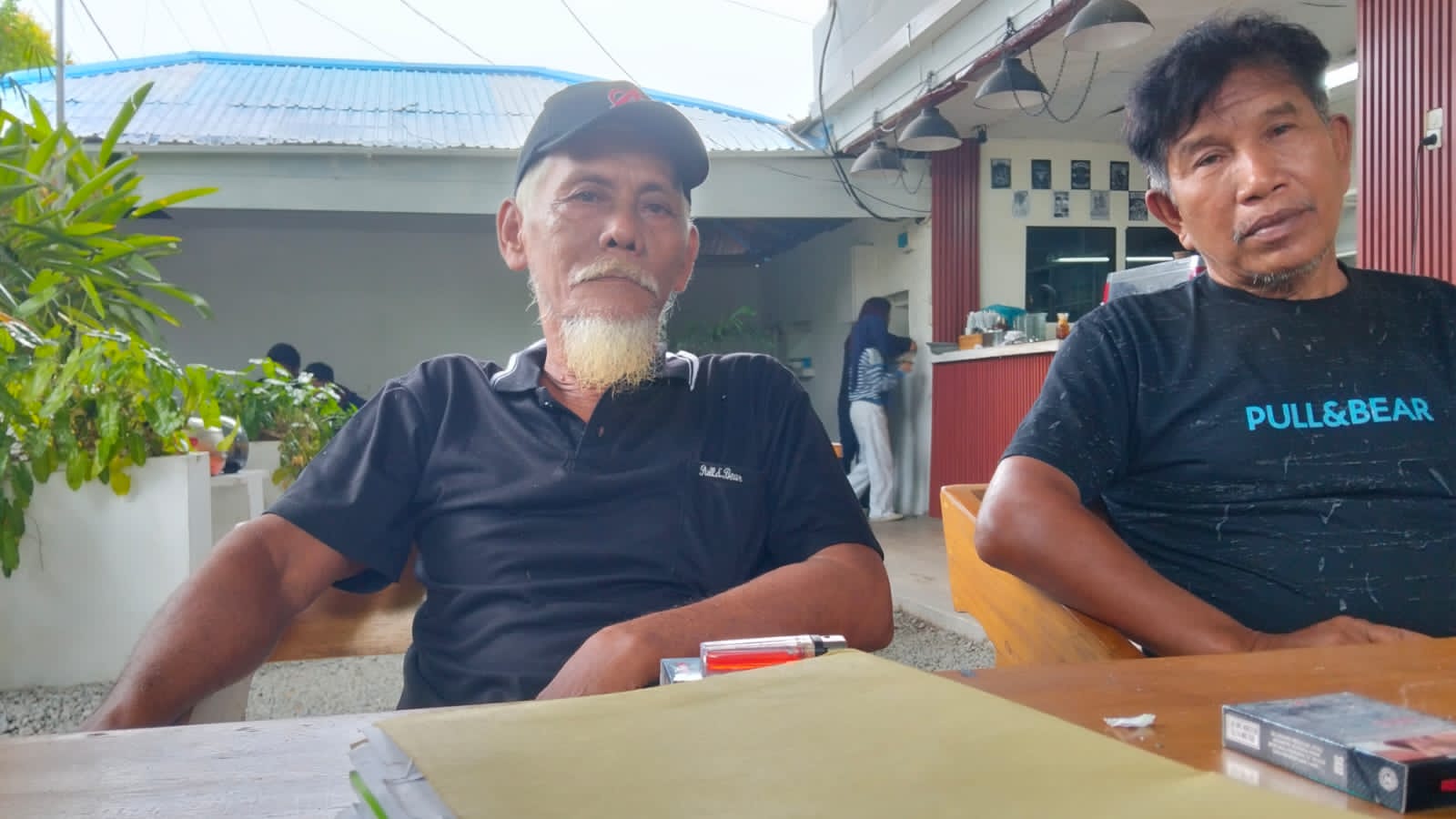 Alismen Dansumara dan warga Desa Ronta memperlihatkan dokumen sengketa lahan Morowali Utara di warung kopi Palu.